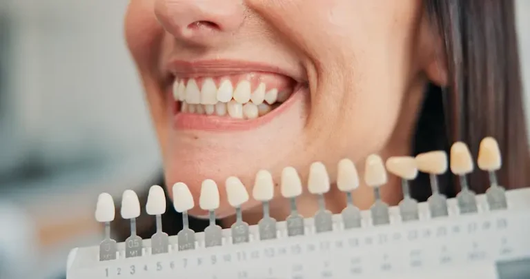 A woman smiles to compare her teeth to a row of the best dental implant options.