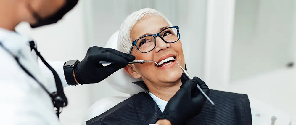 Older woman getting teeth whitening at dentist