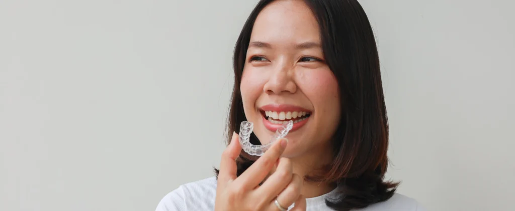 Young woman putting in clear aligner
