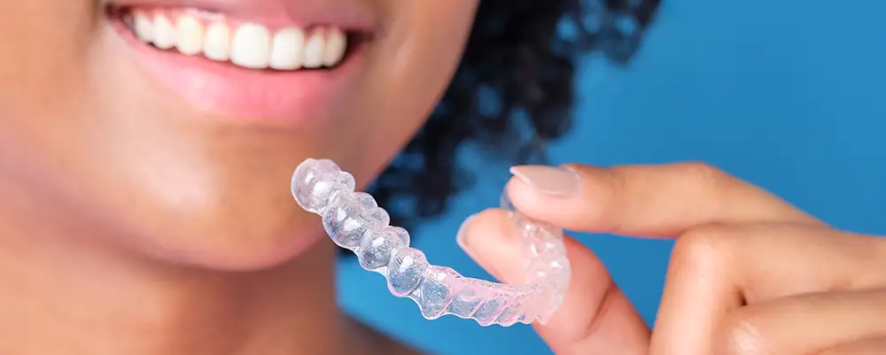 Woman holding up clear aligner