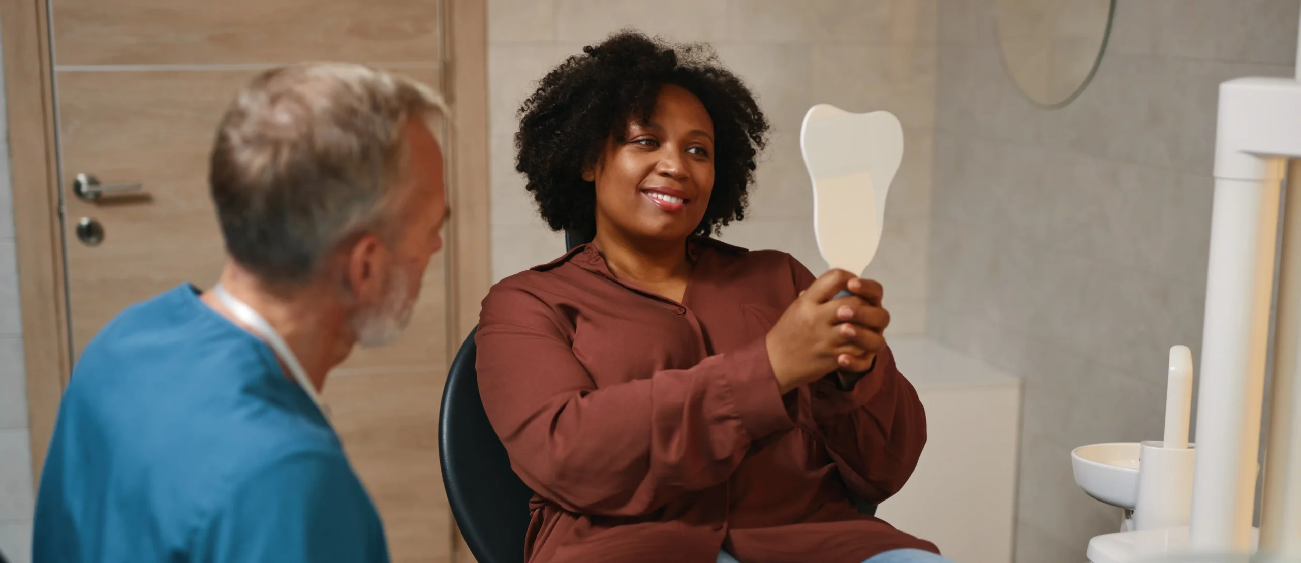 Woman getting dental exam and smiling