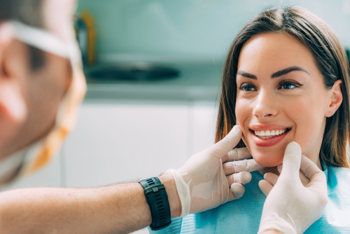 Woman smiling after a cosmetic dental procedure done by a dentist in a cosmetic dentistry office