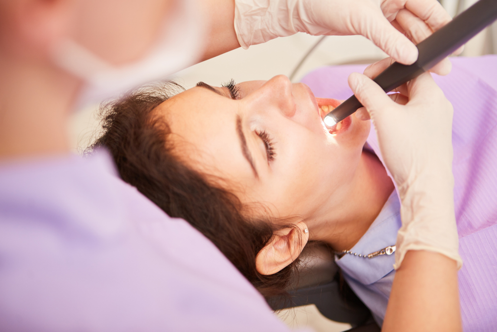 A patient with a toothache is treated by the dentist with a drill against caries