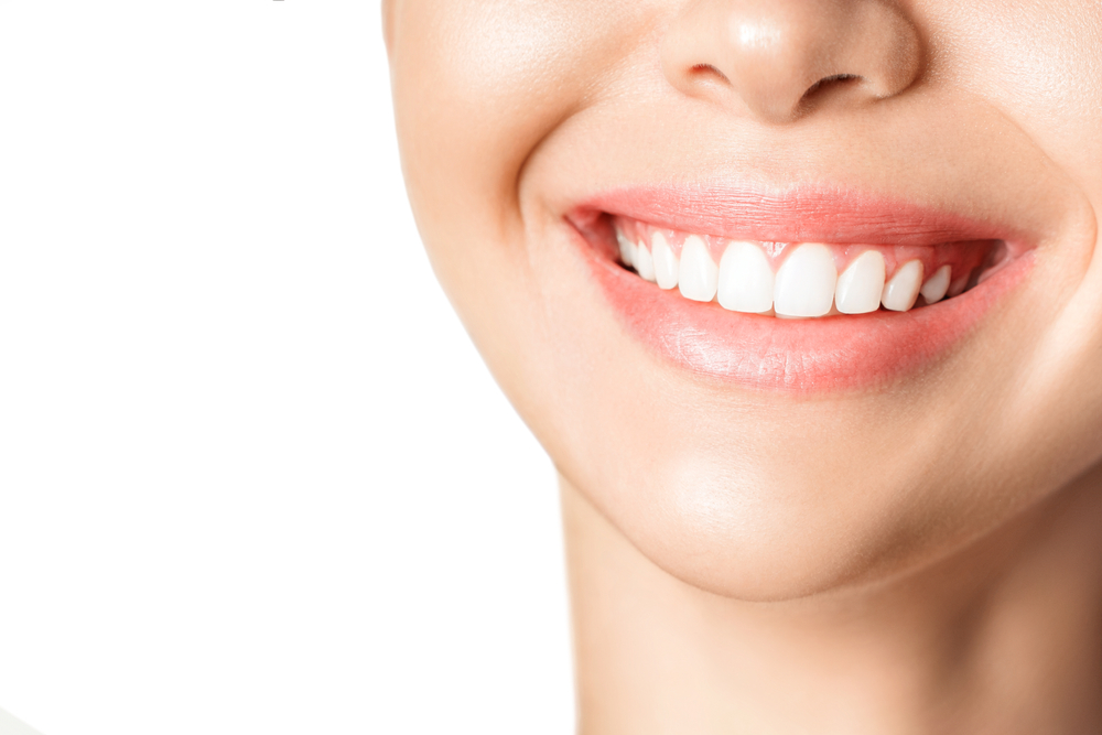 Beautiful young woman with healthy teeth on white background