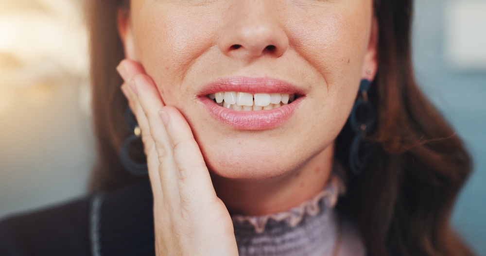 Cavity, teeth and woman with pain, hand and gum disease from bacteria with appointment in clinic. Healthcare, oral health closeup and girl with toothache, sore and swelling with periodontal abscess