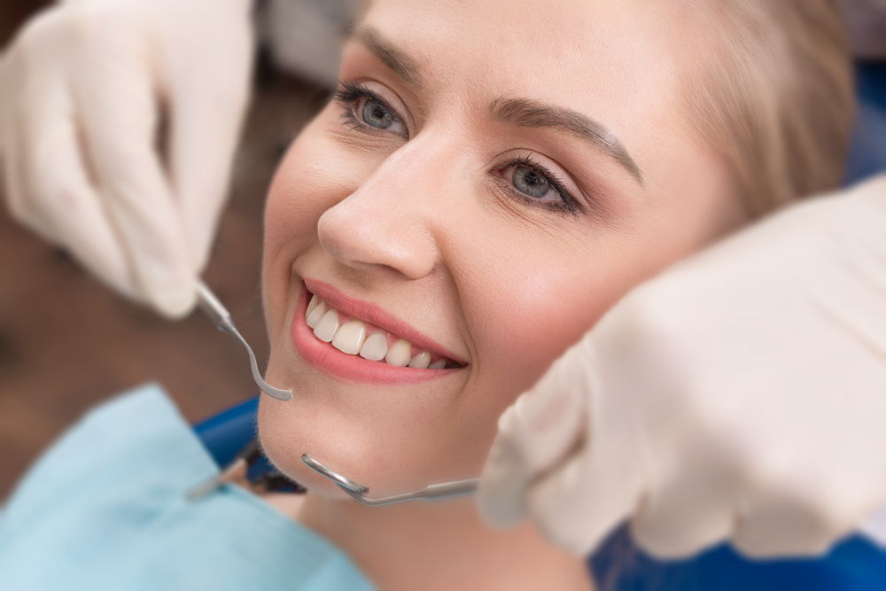 Close-up of female with open mouth during oral checkup at the dentist.Dentist