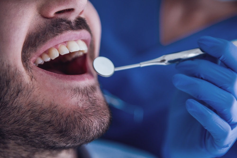 Close-up of handsome young patient visiting a dentist