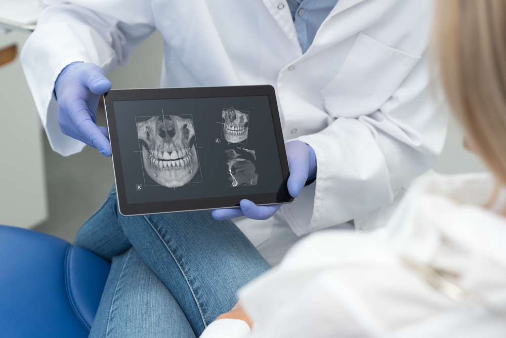 Reviewing digital x-rays with a patient: Norfolk dental office Dentist reviewing digital x-ray images with a patient on a tablet at our Norfolk dental office