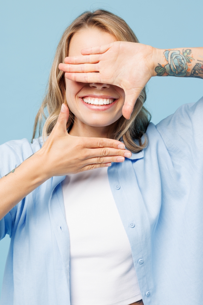  Woman smiling while framing her face with her hands