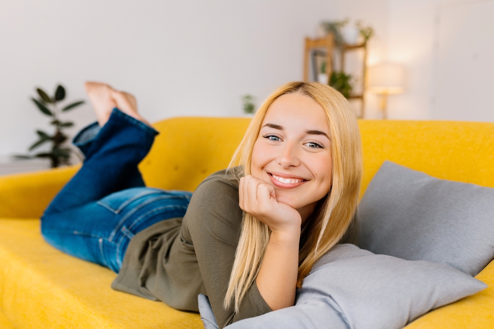 Relaxed smile at home in the Hampton community Woman relaxing on a couch at home in the Hampton community