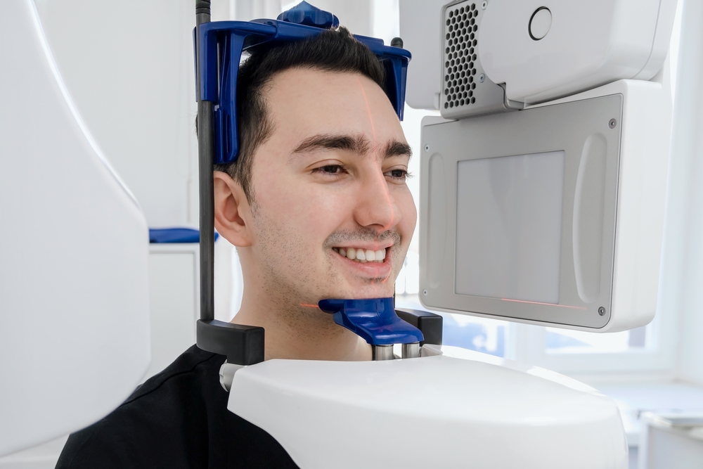 Patient is scanned by 3d dental white equipment X-ray system equipment in modern dental clinic. Interior in dental stomatologist office. High quality close up photo