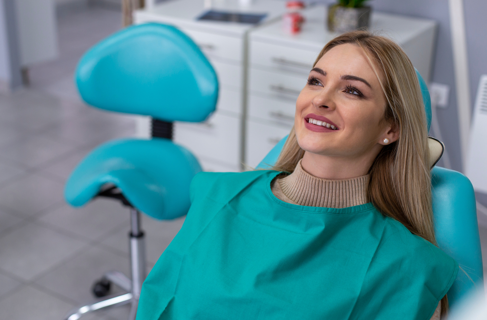 Portrait of the smiling patient in the chair in the dental office.
