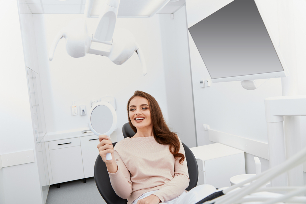 Pretty woman with perfect smile at dentist, at light medical background, portrait, modern clinic, dental clinic, satisfied client, mock-up, close up portrait.