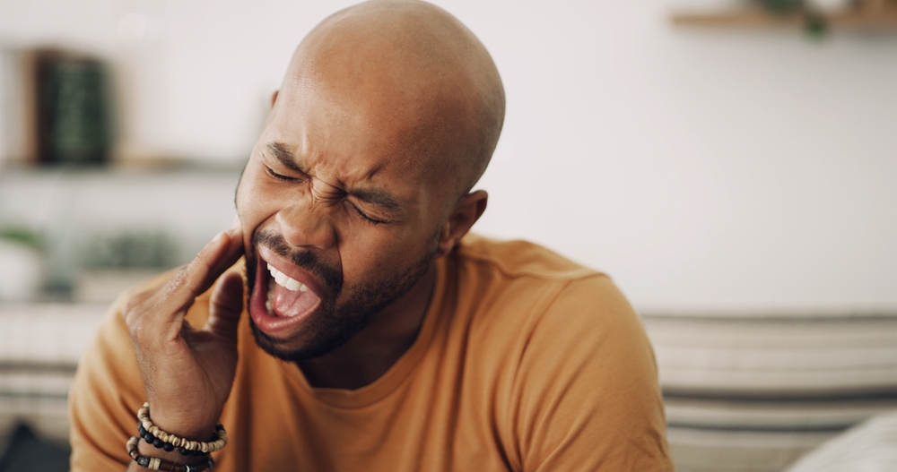 Toothache, pain and man in home with dental problem for cavity, gum disease or gingivitis. Inflammation, dentistry and male person with impacted wisdom teeth for tension, pressure or plaque in house.