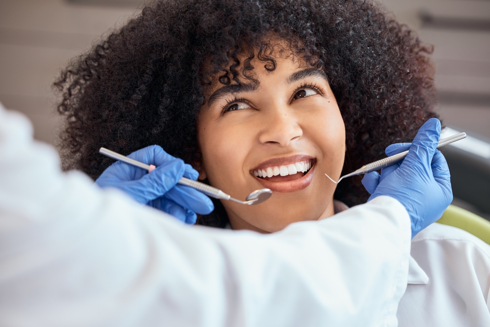 Female, patient and smile in checkup for oral hygiene, mouth and gum healthcare with orthodontist in office