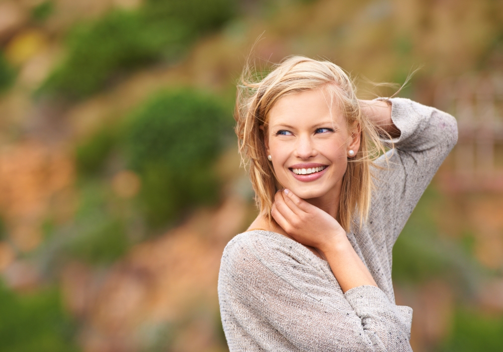 Woman, nature and wind for outdoor travel on holiday vacation with smile for adventure, journey or summer.