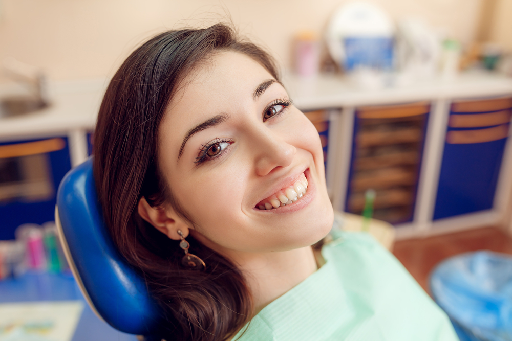 Patient smiling in a dental chair before an exam 