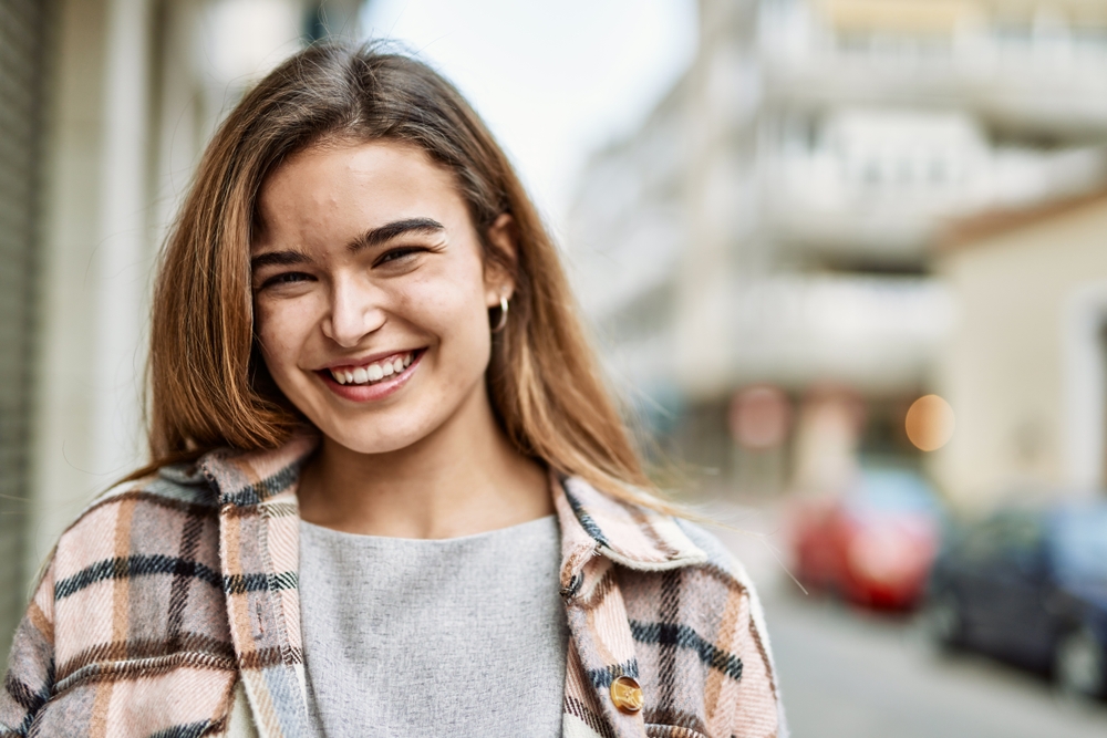 Young blonde woman smiling confident at street