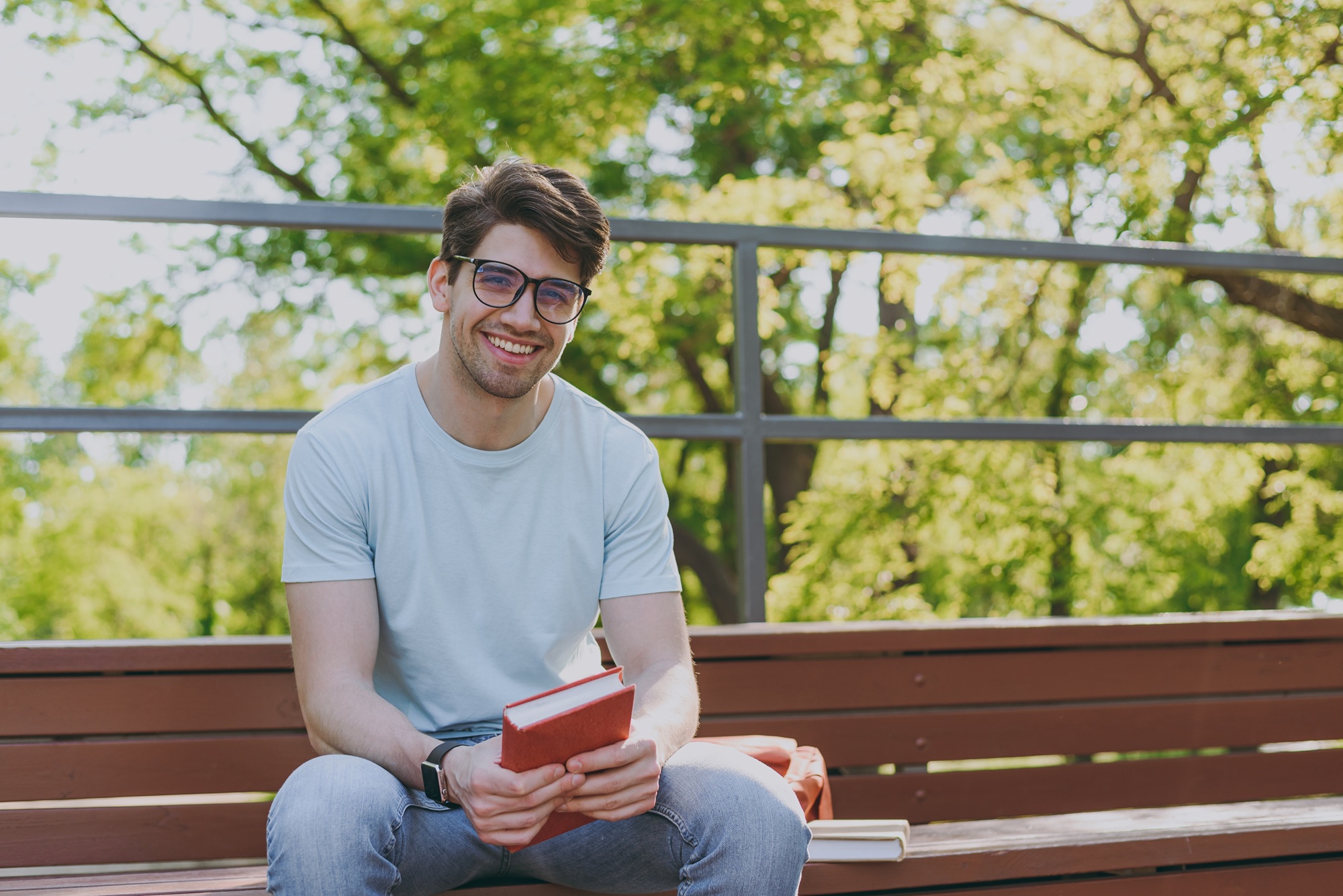 Smiling young man with a bright smile sitting outdoors after a teeth whitening visit in Norfolk 