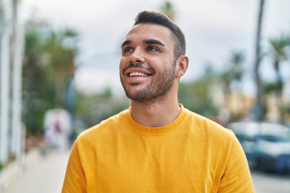 Smiling man outdoors with a confident, healthy smile after full-mouth reconstruction in Norfolk 