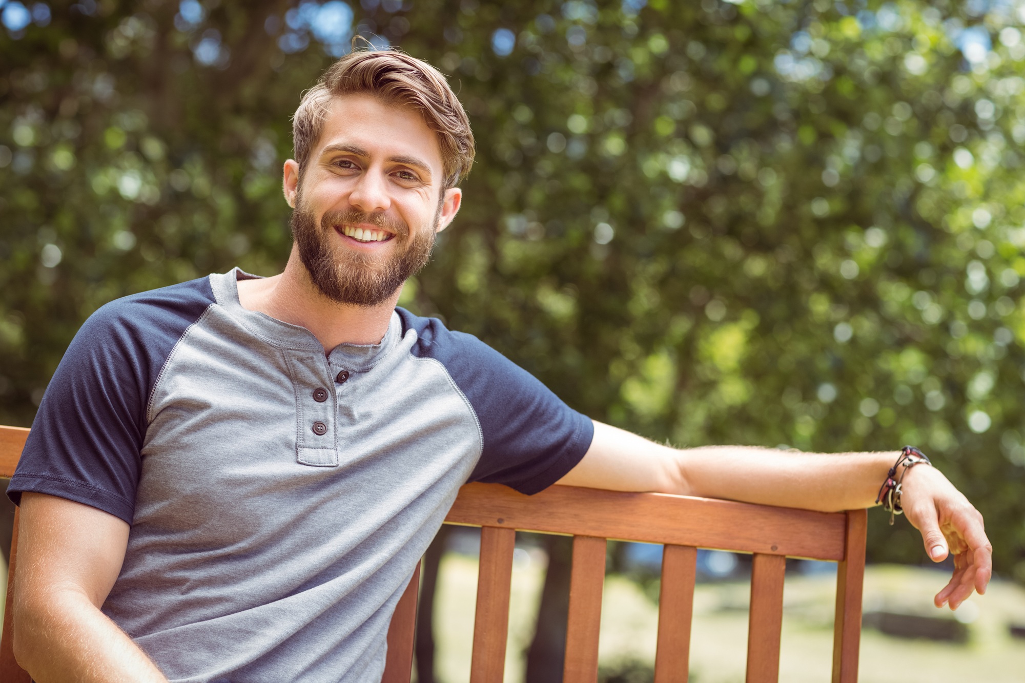 Man smiling confidently outdoors, representing the healthy smiles achieved through orthodontics in the Norfolk community 
