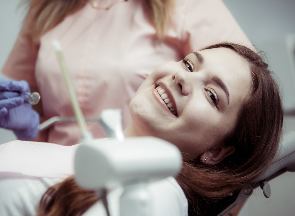 Young smiling woman at the reception at the dentist. Pretty smile