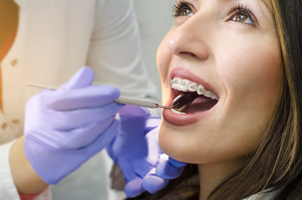 Orthodontist examining a patient's braces with a dental instrument at our Norfolk dental office 