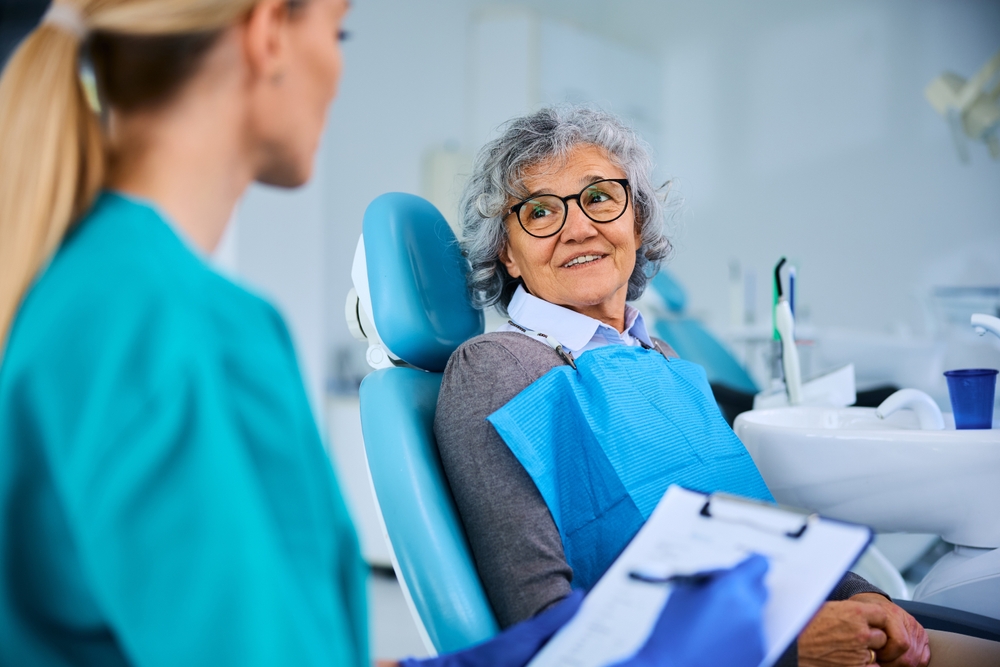 Dental inlay consultations in Virginia Beach Older woman in a dental chair speaking with her dental hygienist