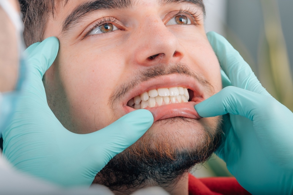 Dentist examining a patient's teeth and gums during a restorative dentistry visit at our Norfolk dental office 