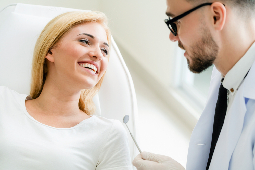 Norfolk dentist consulting with a smiling patient in the treatment chair 