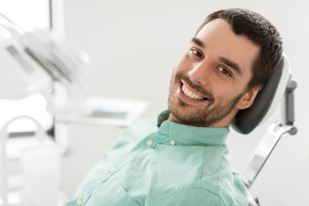 Patient smiling in the treatment chair before a restorative dentistry procedure in Hampton Roads 