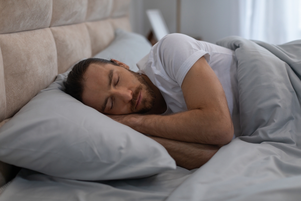 Man sleeping peacefully through the night, reflecting the restful sleep possible after sleep apnea treatment in Hampton 