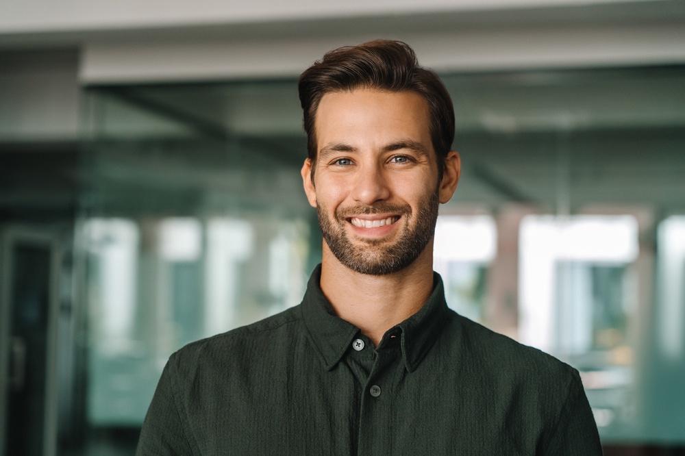 Man smiling confidently in a professional headshot