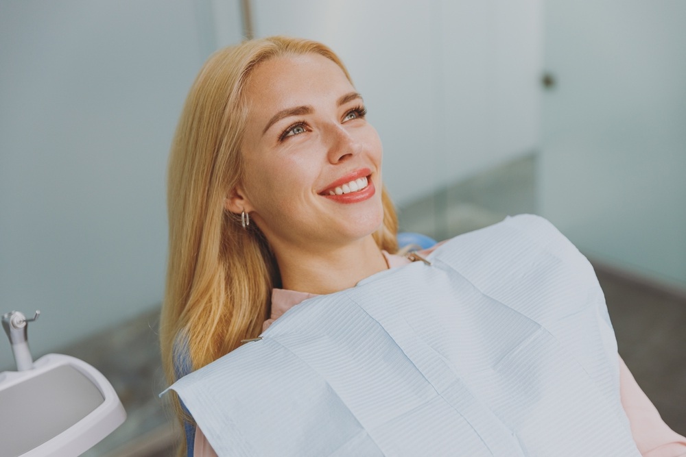 Woman smiling comfortably in the dental chair during a dental implant visit at The Foleck Center, Norfolk, VA 