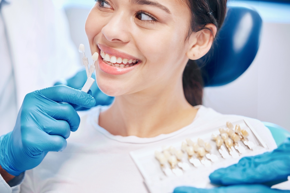 Dental patient smiling during a shade-matching consultation at The Foleck Center in the Suffolk community