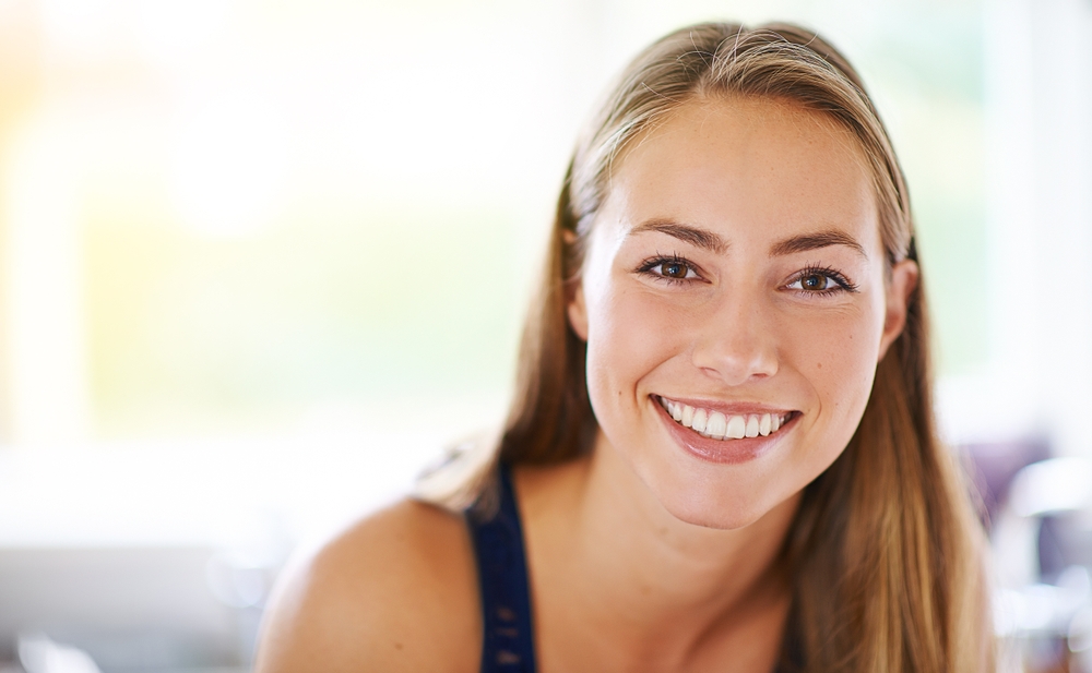 Young woman smiling confidently after periodontal treatment at The Foleck Center in Norfolk 