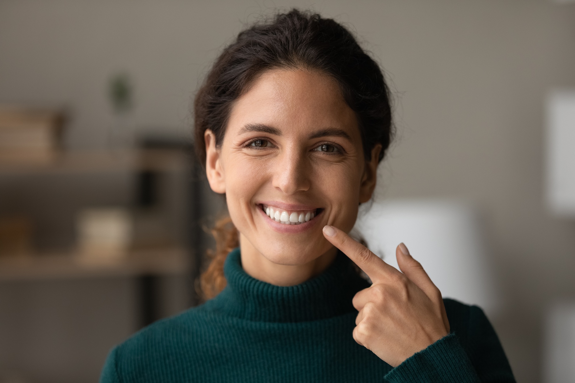 Woman pointing to her smile with her finger