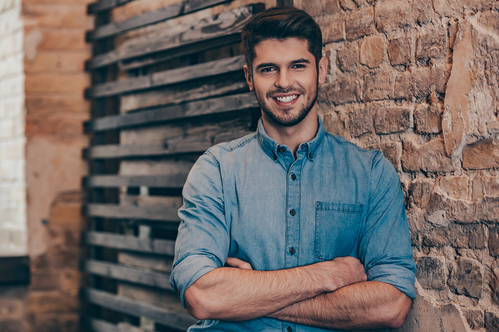 Confident young man smiling outdoors with a healthy, restored smile after dental filling treatment in Norfolk 